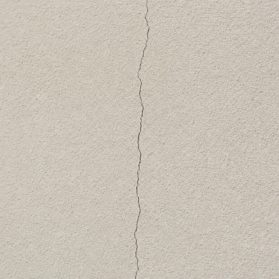 Fissure fine verticale visible sur un enduit de façade